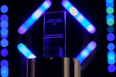 Apbalvojums "Sporta Laureāts 2024" uz tumša fona un neona gaismām