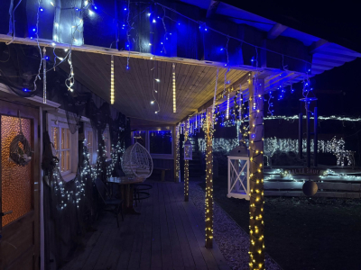 Ar krāsainām Ziemassvētku lampiņām izrotāta nama priekšpuse