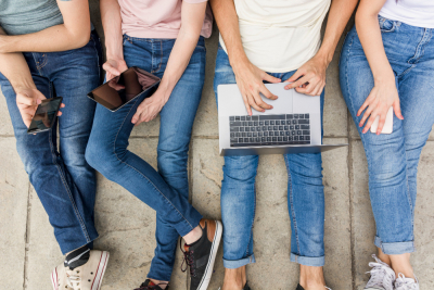 4 personas, kas klēpī katra tur kādu no digitālajiem rīkiem