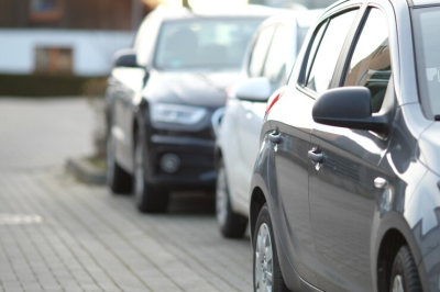 Stāvošasa automašīnas tumšā tonī no sāna