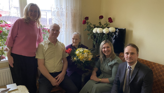 Kandavniece Marta Lietiņa kopā ar sveicēju pulku no pašvaldības.