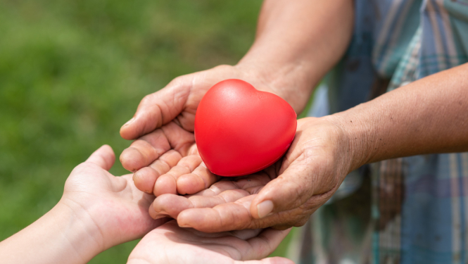 Divi roku pāri, kas kopā tur sarkanu spēļmantu - sirdi