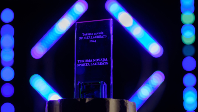 Apbalvojums "Sporta Laureāts 2024" uz tumša fona un neona gaismām