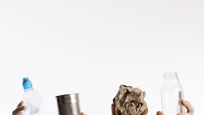 4 rokas ar šķirojamiajiem materiāliem - plasmtasas pudeli, metāla krīzi, papīru un stikla pudeli.