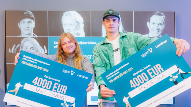 Divi jaunieši ar ziliem plakātiem