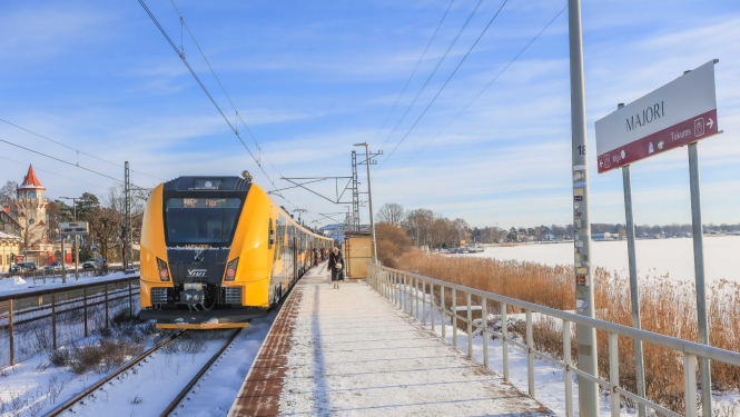 Vivi vilciens uz sliedēm ar sniegu fonā