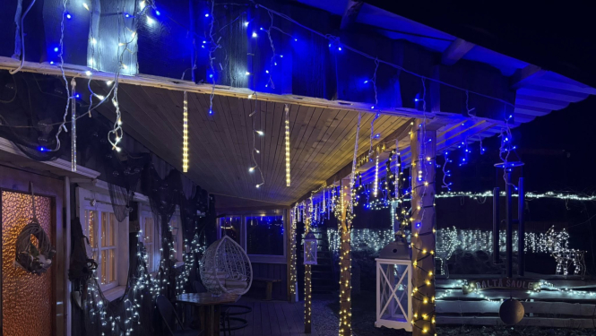 Ar krāsainām Ziemassvētku lampiņām izrotāta nama priekšpuse