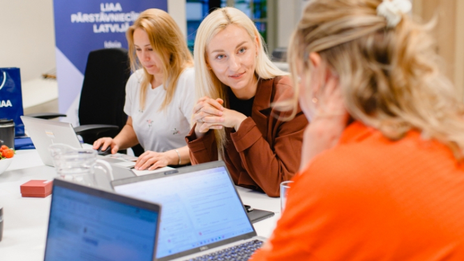 Ilustratīvs foto ar uzņēmējiem pie datoriem