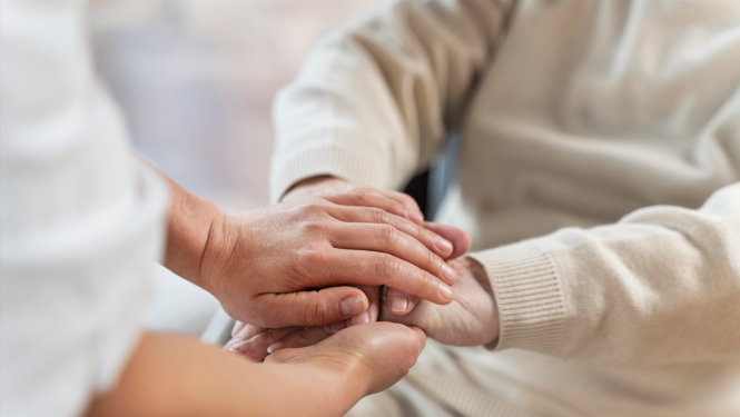 2 cilvēki tur viens otra rokas