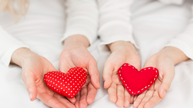 Divi roku pāri, kas katrs tur savu sarkanu filca sirsniņu